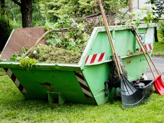 Container mit Gartenabfall, Grünschnitt und Werkzeugen Garten